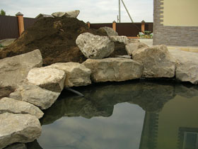 Строительство водоема. Берег водоема
декорируется камнем.